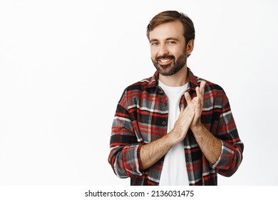 Image of smiling bearded man applausing, clap hands and smiling pleased, praise something good, standing over white background.