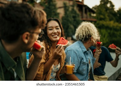 Image of a smiling diverse group of people eating watermelon and having fun during a backyard party.	 - Powered by Shutterstock