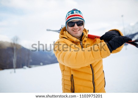 Image of smiling man with mountain skis