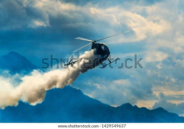 Image of a smoking\
helicopter in flight