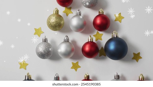 Image of snow falling over christmas baubles and stars. Christmas and celebration concept, digitally generated image. - Powered by Shutterstock