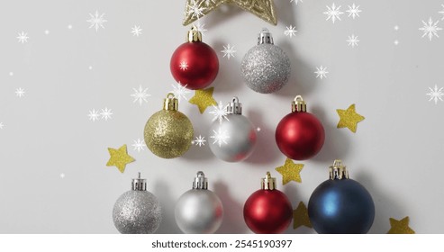 Image of snow falling over christmas baubles and stars. Christmas and celebration concept, digitally generated image. - Powered by Shutterstock