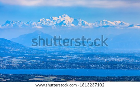 Image of snowcapped Mont Blanc Massif and Leman Lake seen from Jura Mountains in France.