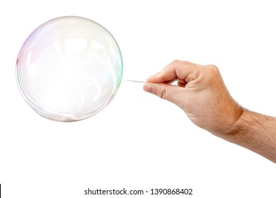 An image of a soap bubble and a males hand with needle to let it pop
