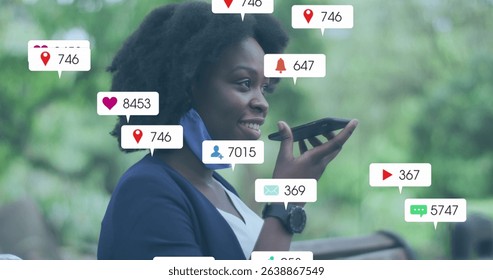 Image of social media icons with growing numbers over african american woman using smartphone. Global social media, technology and digital interface concept digitally generated image.