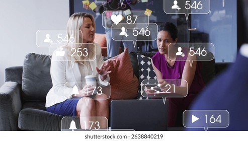 Image of social media icons and numbers over diverse businesswomen. Social media, business, connections and data processing concept digitally generated image.