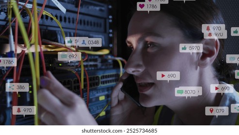 Image of social media icons over caucasian female engineer talking on smartphone at server room. Social media networking and business data storage technology concept - Powered by Shutterstock