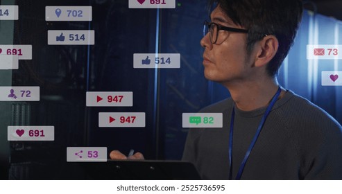 Image of social media icons over asian male engineer writing on clipboard at server room. Social media networking and business data storage technology concept - Powered by Shutterstock