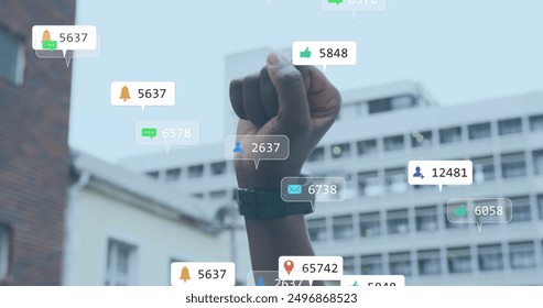 Image of social media notifications over african american woman raising fist in city. Politics, protest, lifestyle, digital interface, social network and communication, digitally generated image. - Powered by Shutterstock