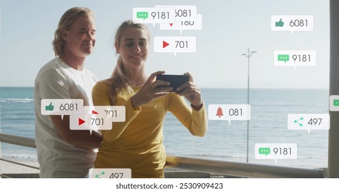 Image of social media notifications over smiling couple taking selfie on holiday by the sea. social media and global communication interface technology concept digitally generated image. - Powered by Shutterstock