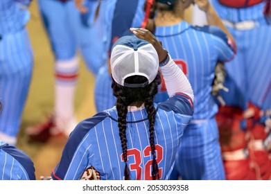 An Image Of A Softball Player Female Athlete Pitcher Is Winding Up To Deliver a Pitch To The Plate - Powered by Shutterstock