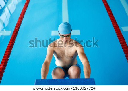 Image of sportive swimmer man in blue cap at side in swimming pool