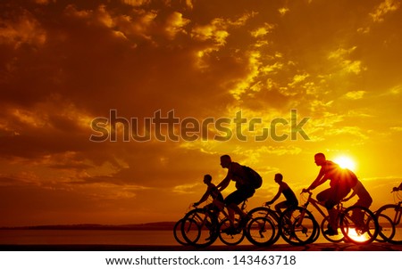 Image of sporty company friends on bicycles outdoors against sunset. Silhouette A lot phases of motion of a single cyclist along the shoreline coast Space for inscription