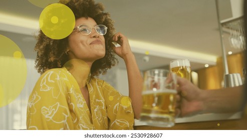 Image of spots over happy biracial woman with caucasian friend drinking beer. social media and communication interface concept digitally generated image. - Powered by Shutterstock