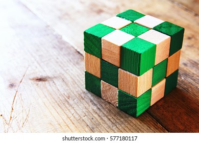 image of square wooden cube puzzle, over wooden table.