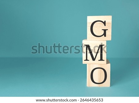 The image is a stack of wooden blocks with the letters GMO on top. Genetically Modified Organism