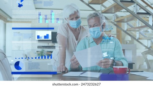 Image of statistical data processing over senior couple wearing face masks reading a document. Business data technology concept - Powered by Shutterstock