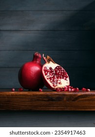 Image of Still Life with Pomegranate. Dark wood background, antique wooden table.