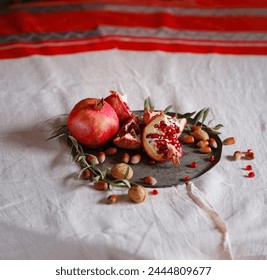 Image of Still Life with Turkish Pomegranate and olive branch on old retro plate. Dark wood background, antique copper plate. Fresh ripe whole pomegranates, opened pomegranate and seeds - Powered by Shutterstock