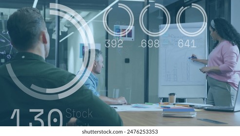 Image of stock market data processing over biracial woman discussing with colleagues at office. Global economy and business technology concept