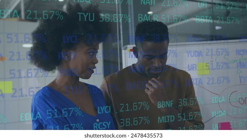 Image of stock market data processing over diverse man and woman discussing at office. Global economy and business technology concept