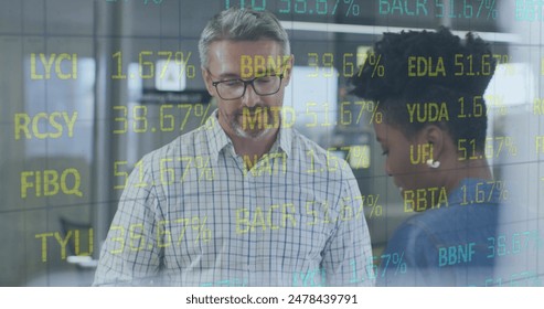 Image of stock market data processing over diverse man and woman discussing at office. Global economy and business technology concept