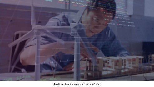 Image of stock market data processing over asian male engineer working on his model at office. Global finance and architectural engineering technology concept - Powered by Shutterstock