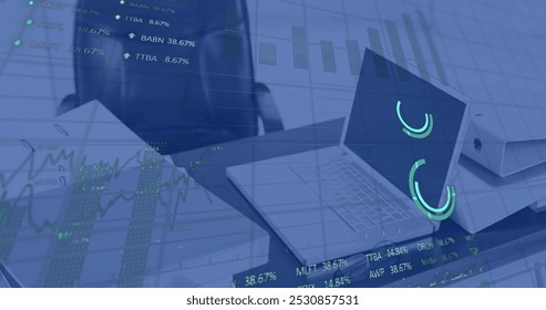 Image of stock market data processing against laptop and documents on office desk. Global economy and business technology concept