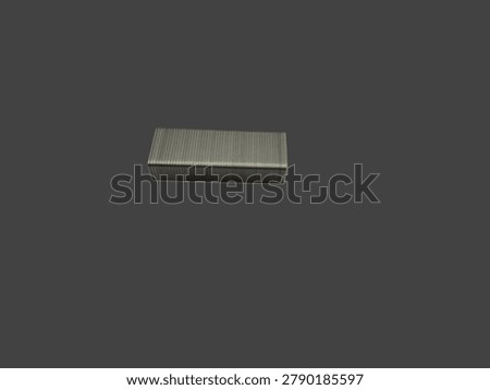 Image of a strip of small staples isolated on a dark background. A staple is a two way fastener, usually made of metal and shaped like a U, used to hold two or more materials together. Larger staples can be used with a hammer or staple gun to hold roofing, wood, cardboard, and other heavy duty materials together. Smaller staples are usually attached to a stapler to hold sheets of paper together