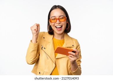 Image Of Stylish Korean Girl Dancing With Smartphone, Laughing Happy And Smiling, Standing Over White Background