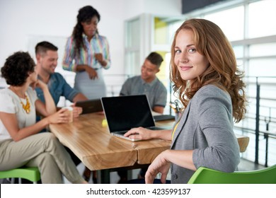 Image of a succesful casual business woman using laptop during meeting - Shutterstock ID 423599137