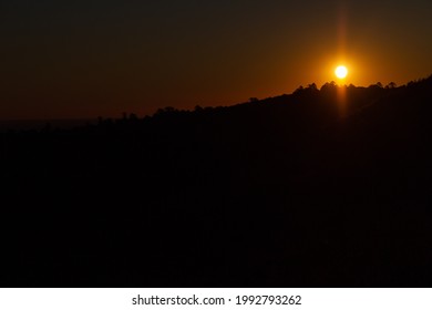 An Image Of The Sun Setting And Silouetting A Ridge Line In Regional Queensland.