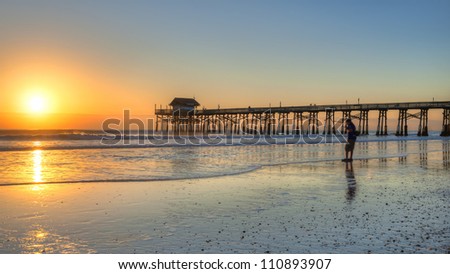 image of sunrise at cocoa beach with silhouette of walker