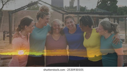 Image of sunset over diverse women at obstacle course embracing. Global sport, health, fitness and digital interface concept digitally generated image. - Powered by Shutterstock