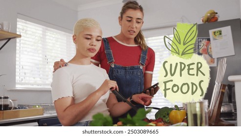 Image of super foods text over diverse female couple cooking at home. Lifestyle, ecology and digital interface concept digitally generated image. - Powered by Shutterstock