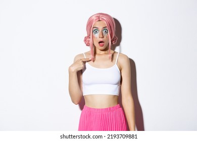 Image Of Surprised Silly Girl With Pink Anime Hair And Bright Makeup, Pointing At Herself With Opened Mouth And Confused Expression, Standing Over White Background