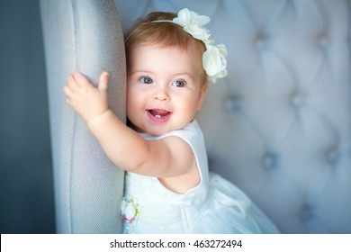 Image of sweet baby girl in a wreath, closeup portrait of cute 8 month-old smiling girl,  toddler.