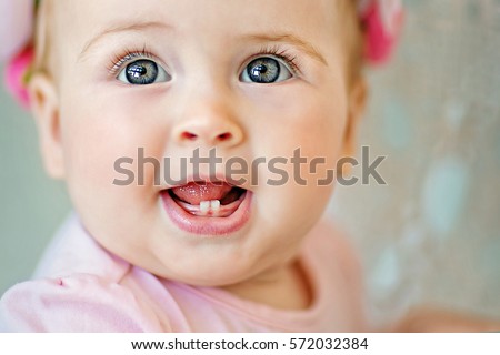 Image of sweet and cute baby girl in pink, closeup portrait of cute 8 month-old smiling girl,  toddler.