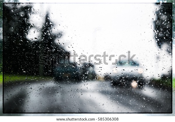 Image taken\
through a rain splashed windscreen of cars with headlights on a\
rainy day. Shows motion blur in\
cars.