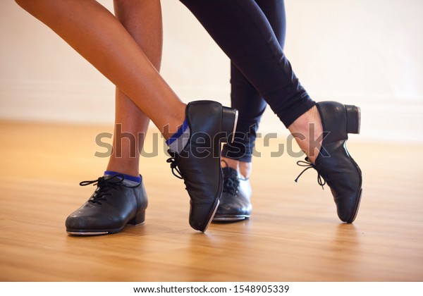 Image of tap shoes from a tap dance class in a\
dance studio.