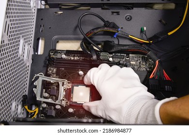 Image of a technician inserting a CPU chip onto a computer motherboard.