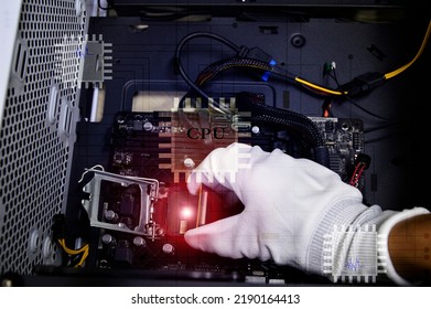 Image of a technician inserting a CPU chip onto a computer motherboard.