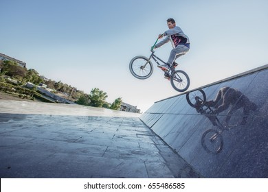 Image Of Teenager On A Bicycle In A Jump On A Background Blue Sky.