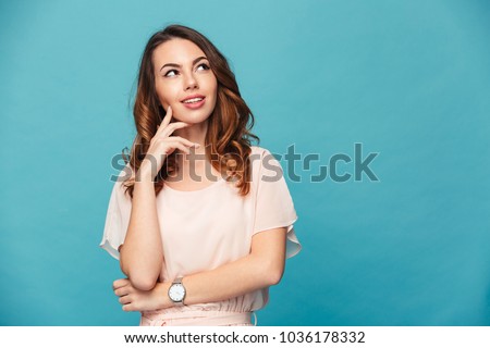 Image of thinking young lady standing isolated over blue background. Looking aside.