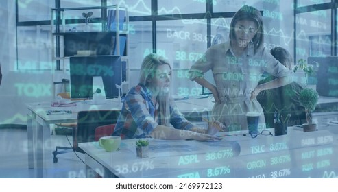 Image of trading board over diverse female architects discussing blueprint in office. Digital composite, multiple exposure, business, planning, teamwork, stock market and technology concept. - Powered by Shutterstock