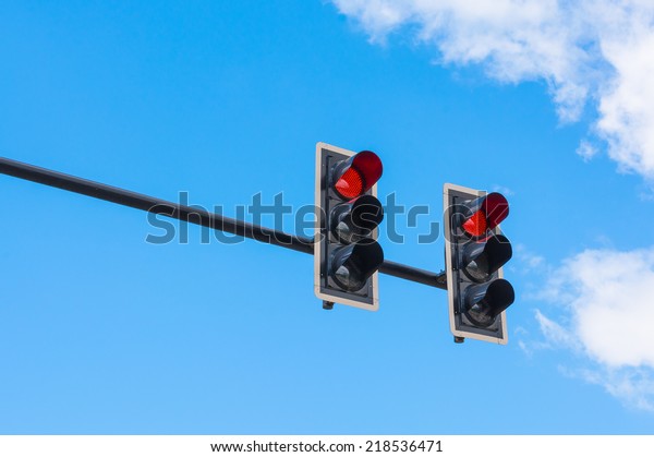 image of traffic light, the red light is lit.\
symbolic  for holding.