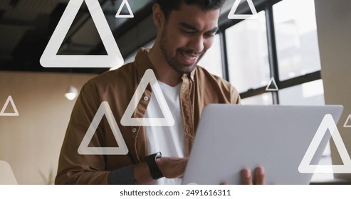 Image of triangles over biracial businessman working at office. Global business, finances and digital interface concept digitally generated image. - Powered by Shutterstock