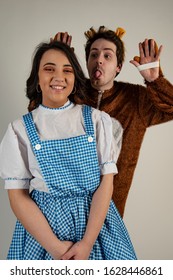 A Image Of Two Actors Reading  Dressed Up In Fancy Dress For The Pantomime. 