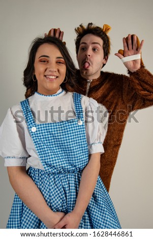 A image of two actors reading  dressed up in fancy dress for the pantomime. 