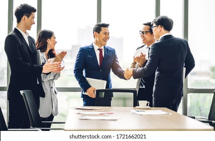 Image Two Asian Business Partners In Elegant Suit Successful Handshake Together In Front Of Group Of Casual Business Clapping Hands In Modern Office.Partnership Approval And Thanks Gesture Concept